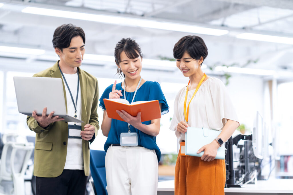 会議で資料を見ながら話し合う女性社員。自分軸、納得できるキャリアコーチングができるCalmee（カーミー）