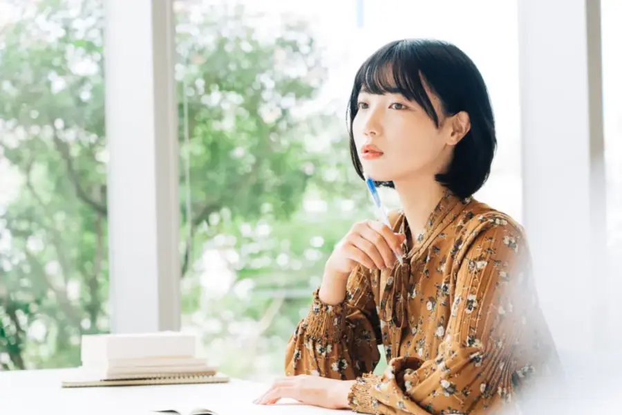 Calmeeでキャリアコーチングを検討する女性がパソコンの前で考えている様子